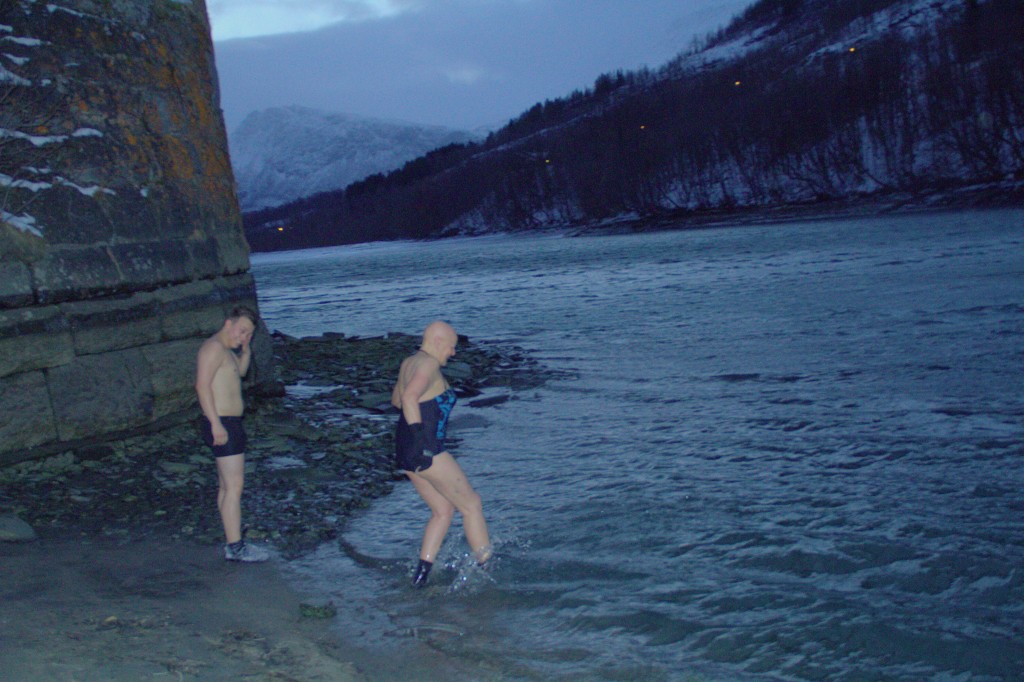 Pål Vegard Eriksen ser litt skeptisk ut før han går ut i det iskalde vannet sammen med den erfarne isbaderen Bente Imerslund. Kuva: Halti Kvenkultursenter