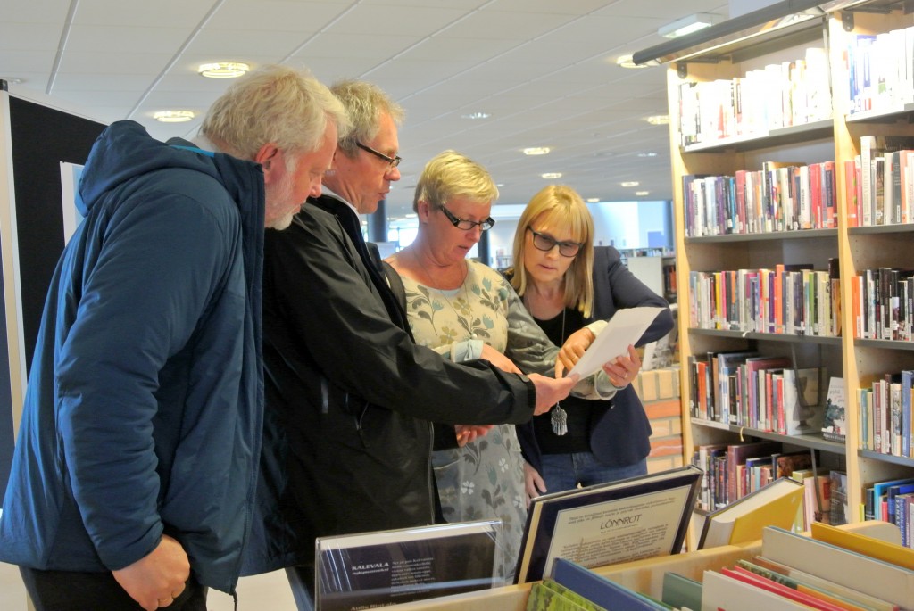 Riksantikvar Jørn Holme, Finlands ambassadør Erik Lundgren og hans kone fikk se på gamle finske dokumenter på biblioteket i Vadsø. KUVA HEIDI NILIMA MONSEN